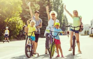 grupo do pessoas juntando seus mãos enquanto segurando seus bicicletas foto