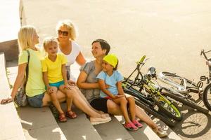 família em repouso dentro verão parque com bicicletas foto