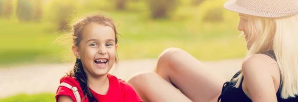 feliz família em uma verão Prado. pequeno menina criança filha abraçando e se beijando mãe foto