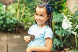 criança com uma borboleta em dele nariz. fada sonhos para Princesa garota. feliz infância conceito. foto