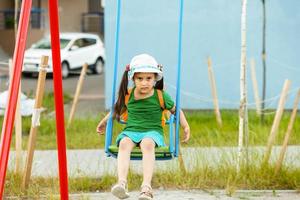 criança ásia menina tendo Diversão para jogar balanço dentro Parque infantil dentro vintage cor tom foto