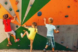 dois pequeno meninas Garoto escalada uma Rocha parede foto