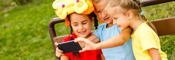 feliz crianças levando uma selfie com inteligente telefone. temas amizade, verão e moderno tecnologia foto