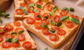 delicioso fresco torrada ou Brusqueta com tomates, queijo, ervas, sal e especiarias foto