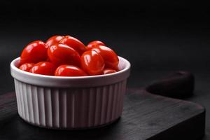 fresco saboroso cereja tomates dentro uma branco com nervuras tigela foto