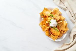 chips de tortilha de nachos com jalapeño, guacamole, molho de tomate e molho foto