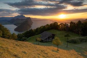 uma panorama tiro a partir de uma montanha negligenciar uma lago durante a dourado hora foto