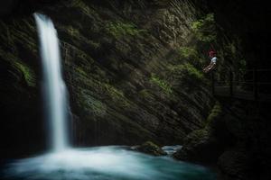 uma místico cachoeira, em uma andaime senta uma pensativo pessoa foto