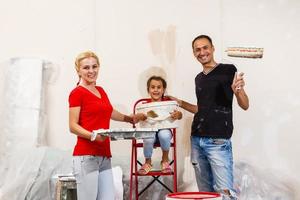 jovem família fazendo pintura trabalho durante casa renovação foto