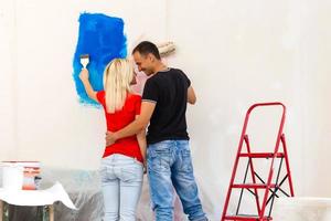 jovem família fazendo pintura trabalho durante casa renovação foto