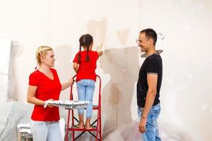 jovem família fazendo pintura trabalho durante casa renovação foto