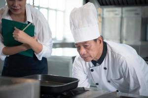 a chefe de cozinha tem para ao controle a calor do a fogão somente certo para grade a bife tão este a maturação do a carne é de acordo com para a clientes desejo foto