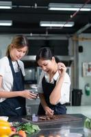 alunos cozinhando Aprendiz depois de a bife é acabado grelhar, experimentar aspersão sal a partir de famoso chefs de aspersão sal sobre seu cotovelos. foto