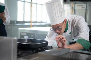 a chefe de cozinha tem para ao controle a calor do a fogão somente certo para grade a bife tão este a maturação do a carne é de acordo com para a clientes desejo foto