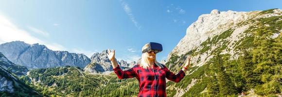 menina dentro capacete virtual realidade vr em a topo montanha desfrutando inverno panorama foto