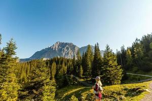 mulher desfrutando beleza do natureza olhando às montanha. aventura viagem, Europa. mulher carrinhos em fundo com Alpes. foto