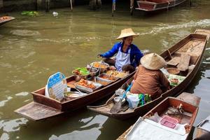 barcos vendendo vários frutas e Comida às a flutuando mercado estão popular turista atrações com tradicional Vila vida-10-8-2014-damnoen Saduak Ratchaburi foto