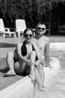 cara e uma menina dentro tomando banho ternos estão relaxante, perto a azul piscina foto