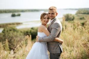 jovem casal uma cara e uma menina estão caminhando dentro a verde colinas foto