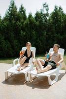 cara e uma menina dentro tomando banho ternos estão relaxante, perto a azul piscina foto