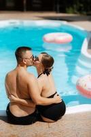 cara e uma menina dentro tomando banho ternos estão relaxante, perto a azul piscina foto