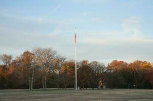 bandeira pólo às pés caçar parque com Relva e árvores foto