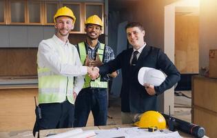 conceito de construção e estrutura de reunião de engenheiro ou arquiteto para projeto trabalhando com parceiros e ferramentas de engenharia na construção de modelo e projeto no local de trabalho, contrato para ambas as empresas. foto