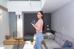 inteligente casa tecnologia interface em inteligente controler aplicativo tela com aumentado realidade Visão do Internet do coisas conectado objetos dentro a apartamento interior, pessoa segurando dispositivo foto