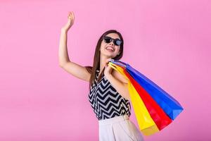 alegre feliz mulher desfrutando compras, ela é carregando compras bolsas e corrida para pegue a Mais recentes ofertas às a compras Centro foto