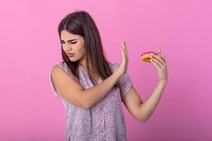 mulher em dieta para Boa saúde conceito. fechar acima fêmea usando mão empurrar Fora dela favorito rosquinha para Boa saúde. dieta, dieta conceito. lixo comida, emagrecimento, peso perda foto