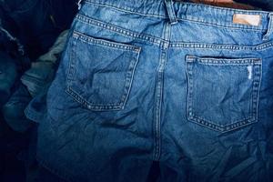 tecido textura, fechar acima do azul jeans brim textura com costas bolso detalhe..destruído rasgado clássico jeans azul jeans remendos, bandeira moda fundo foto