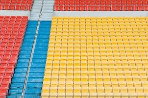 assentos laranja e amarelos vazios no estádio, fileiras de assentos em um estádio de futebol foto