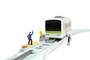 equipe ferroviária em miniatura trabalhando na ferrovia s em um fundo branco foto