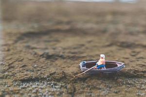 pescador em miniatura pescando em um barco foto