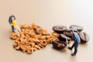 equipes em miniatura trabalhando juntas na mistura de café foto