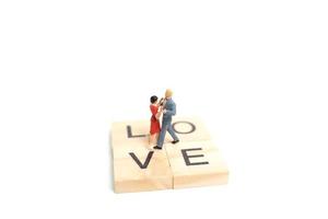 casal em miniatura dançando romanticamente em um fundo branco, conceito do dia dos namorados foto
