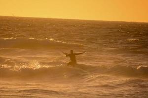 kitesurfer às pôr do sol foto