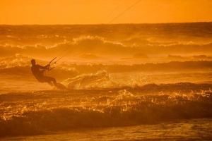 kitesurfer às pôr do sol foto