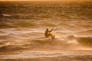 kitesurfer às pôr do sol foto