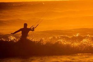 kitesurfer às pôr do sol foto