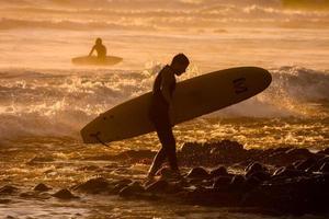 surfista ao pôr do sol foto