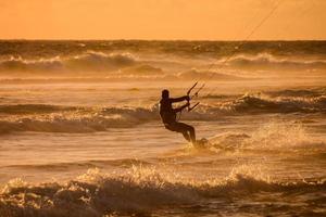 kitesurfer às pôr do sol foto