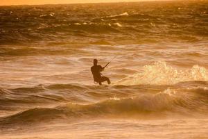 kitesurfer às pôr do sol foto