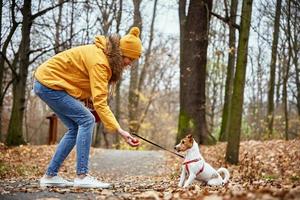 mulher com cachorro passear no parque outono foto