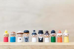 bonecos de madeira em miniatura com rostos felizes em um fundo de madeira foto
