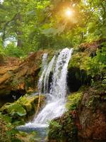 lindo cascata dentro profundo floresta e natural com brilhando nascer do sol. foto