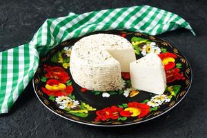 queijo branco em um prato em um fundo preto e guardanapo foto