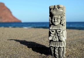 pequena estátua na areia foto