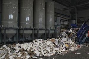 trituração correia transportadora de resíduos de papel para reciclagem de envoltório, lixo e papelão contra fardos de caixas de papelão usadas coletadas para reutilização na fábrica de plantas industriais. desperdício zero, conceito ecológico foto