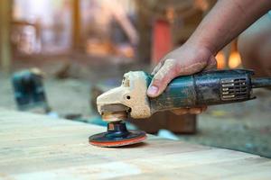 carpinteiros usar uma lixadeira para areia a superfície do a madeira para suave a madeira antes pintura. suave e seletivo foco. foto